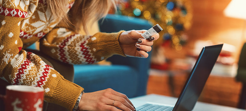 Person holding credit card in front of computer